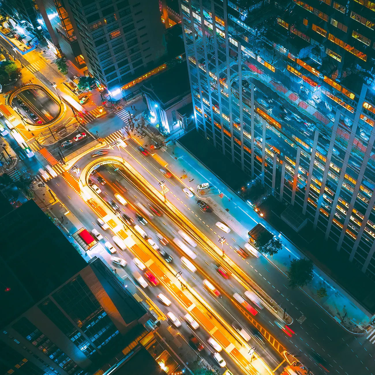 Night aerial view of busy city traffic and illuminated streets.
