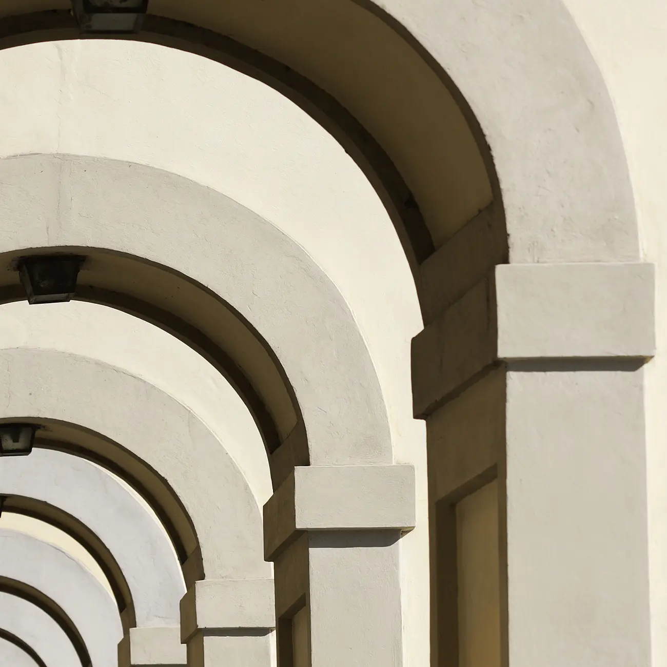 Row of stone arches in classical architectural corridor.