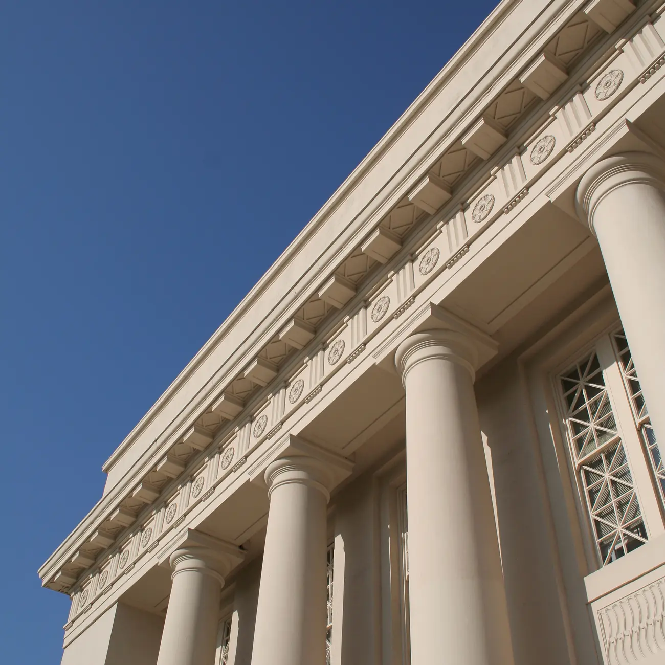 Neoclassical building with large columns against blue sky.