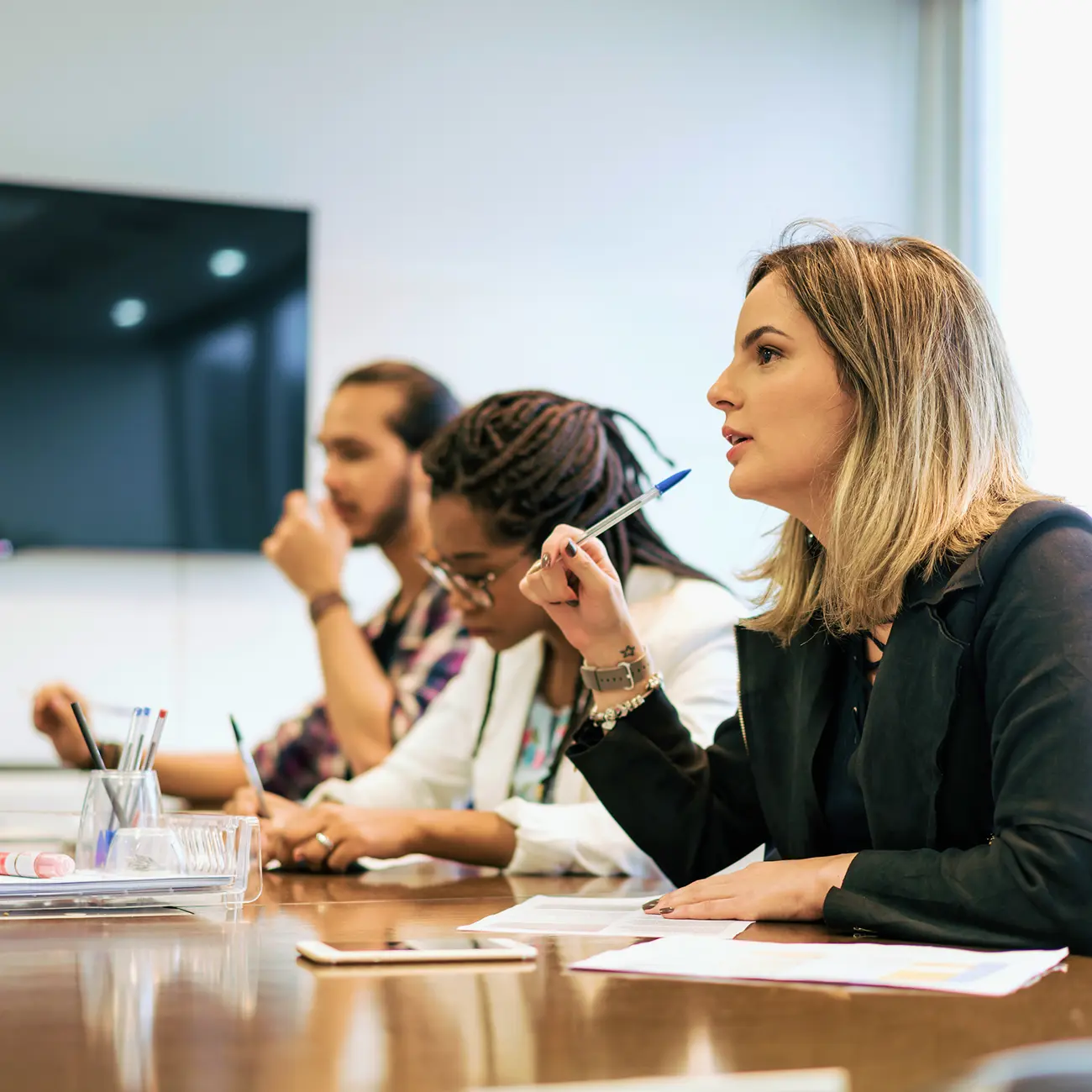 Professionals taking notes during a meeting.