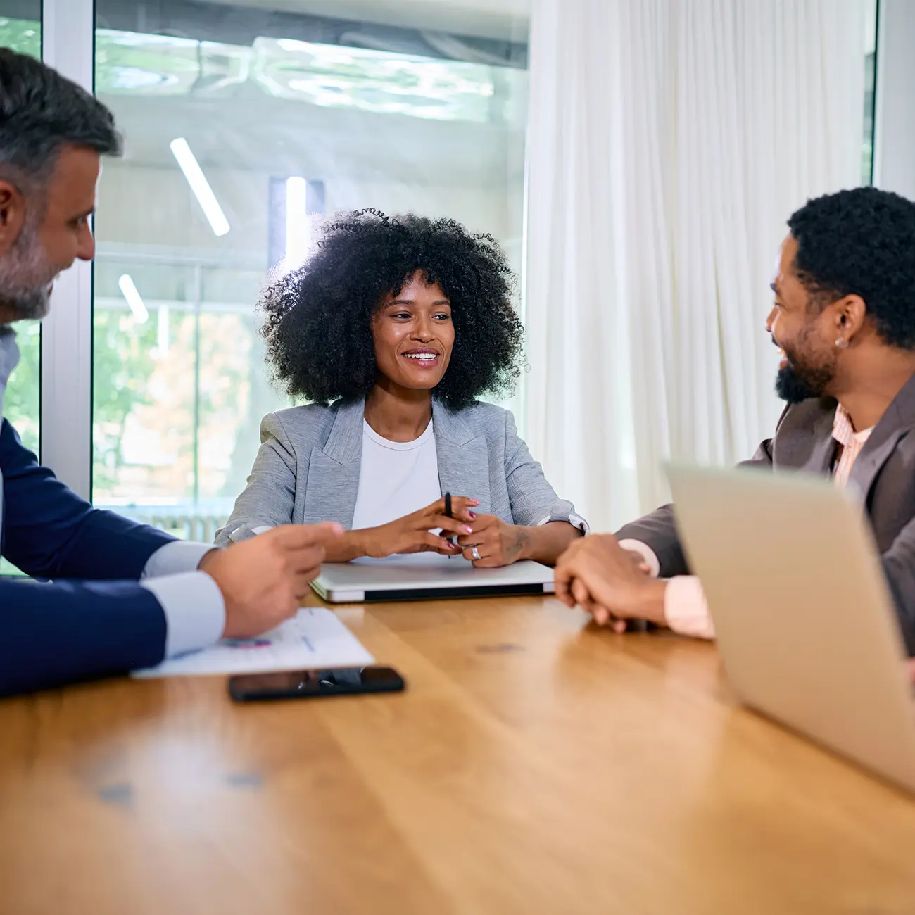 Three coworkers discussing ideas in a meeting.