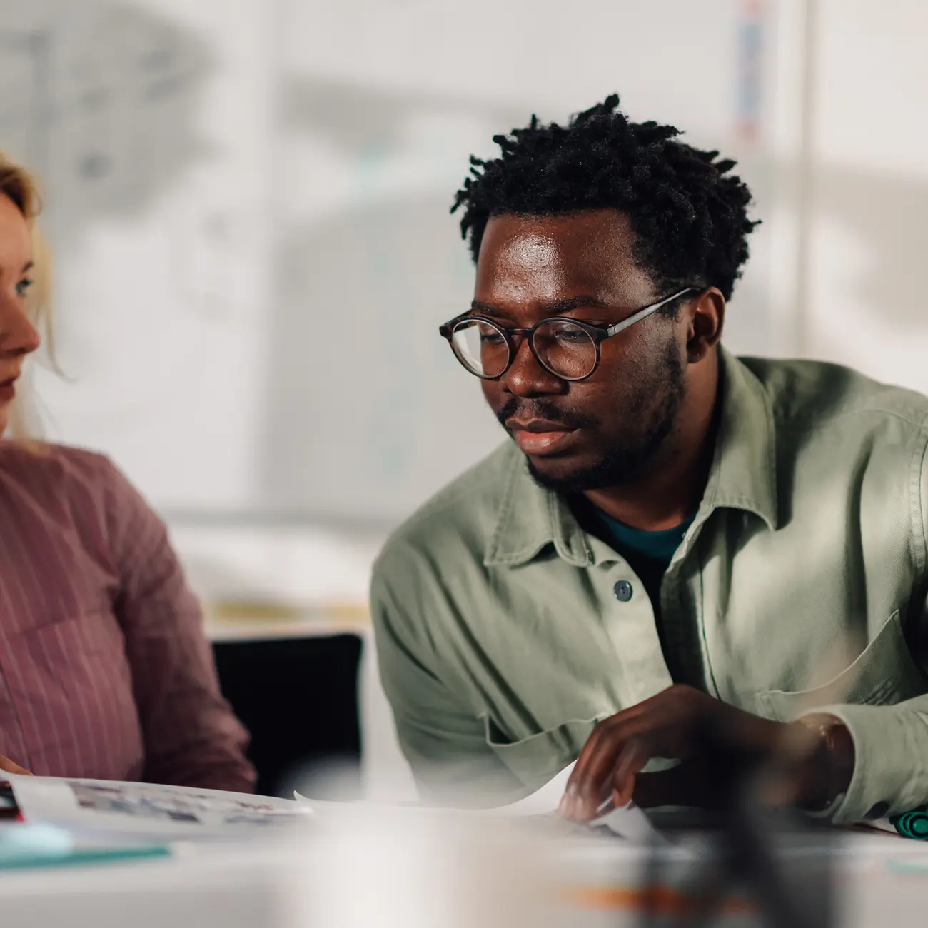 Colleagues reviewing documents together in an office.