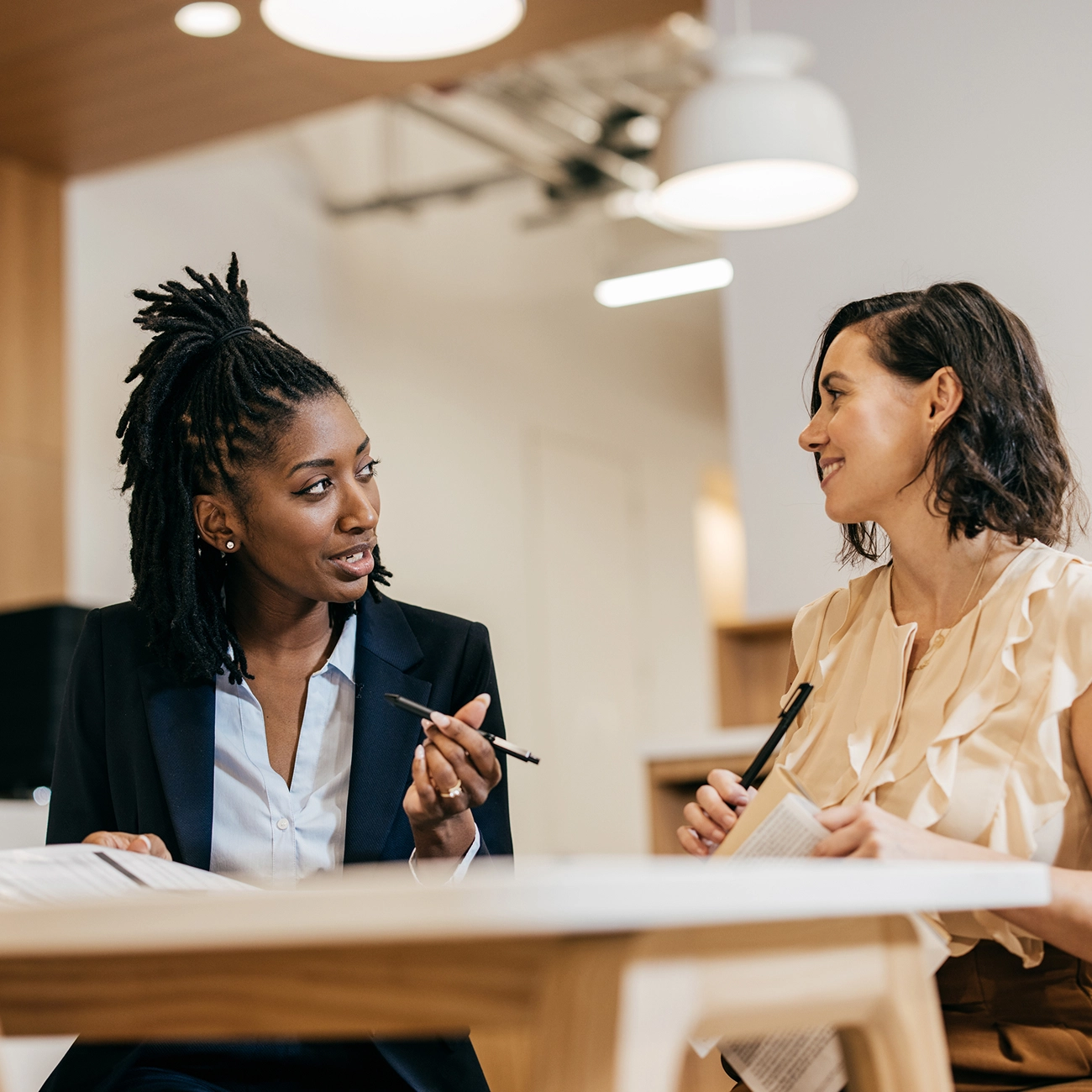 Two professionals reviewing documents at a desk.