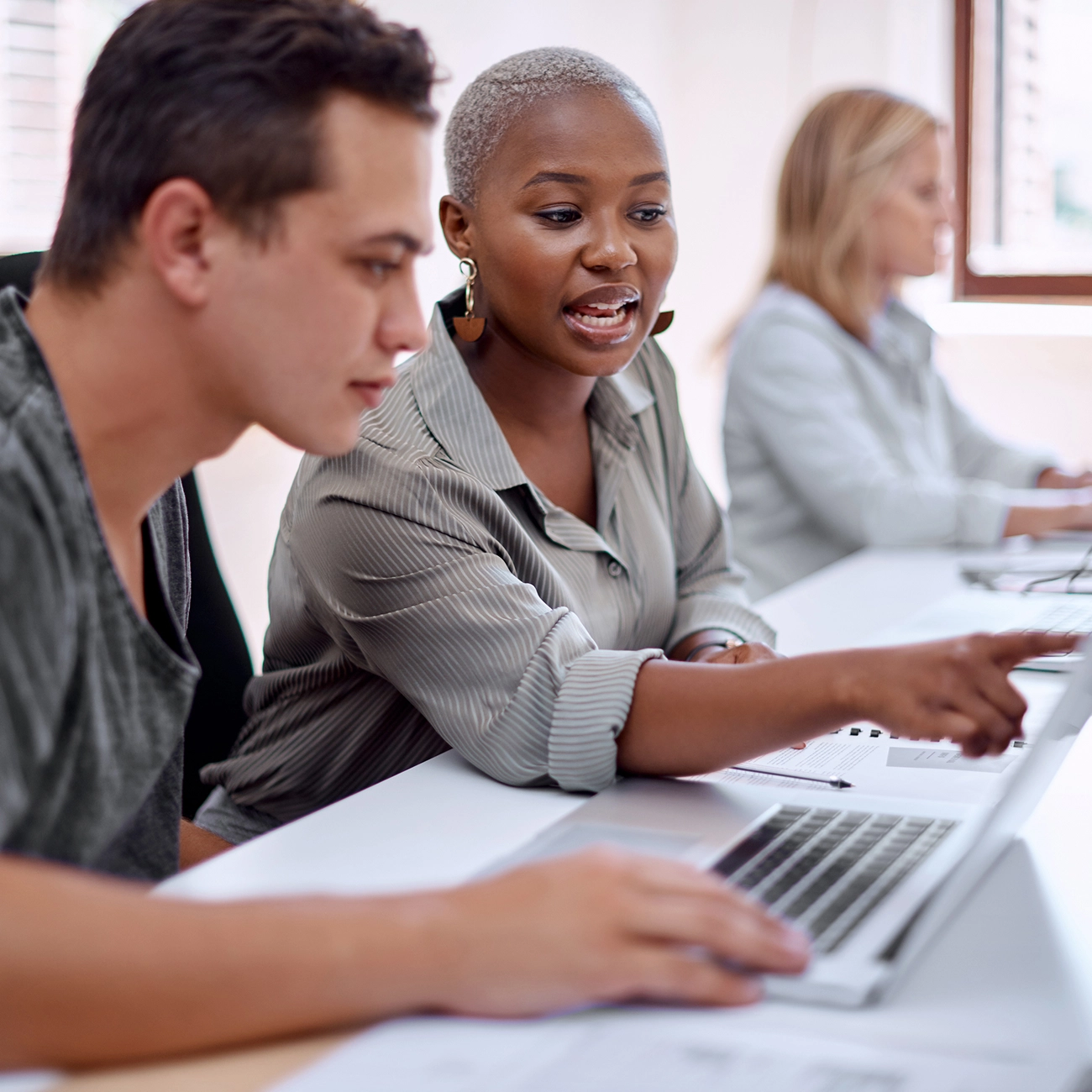 Colleagues reviewing data together on a laptop.