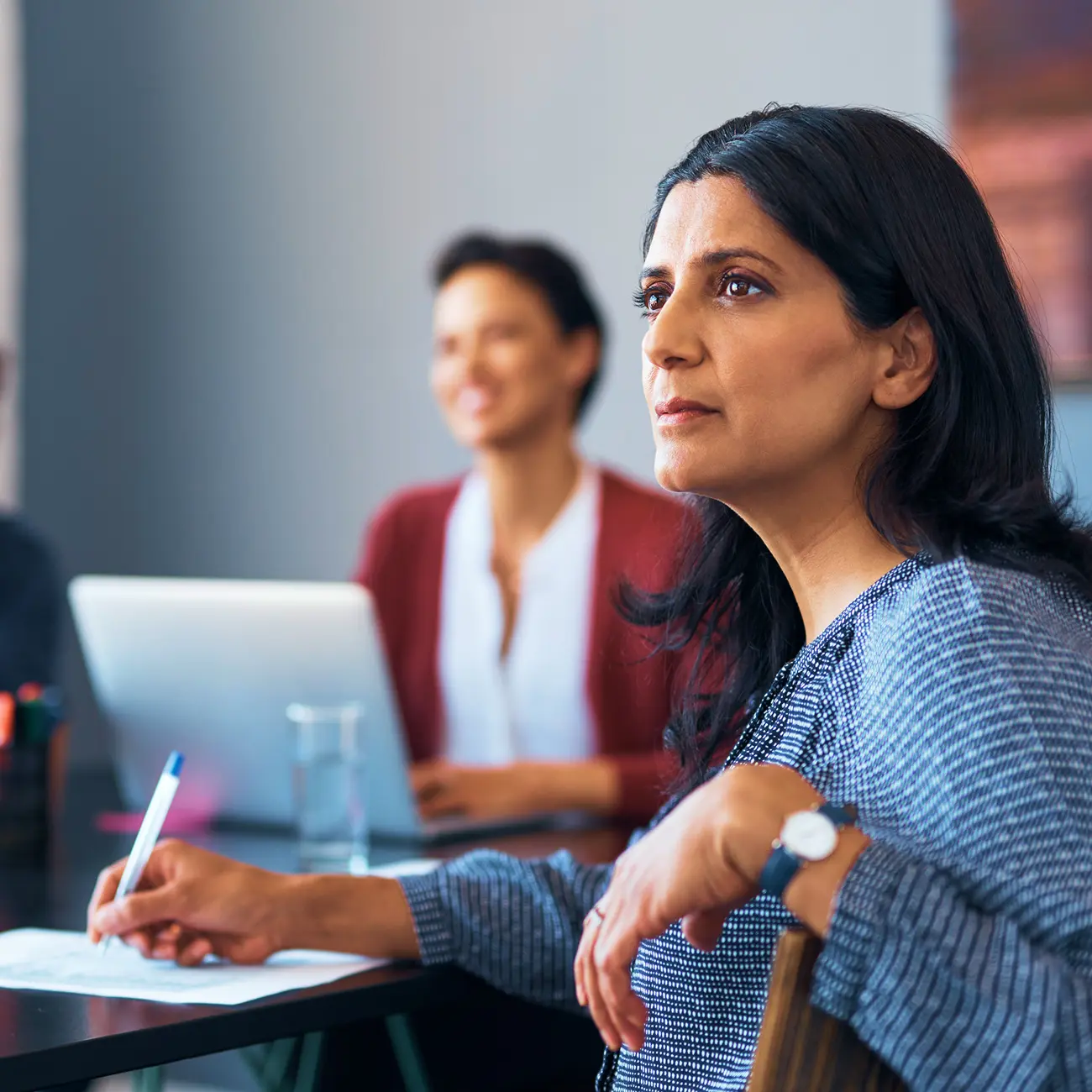 Professional woman taking notes during a meeting.