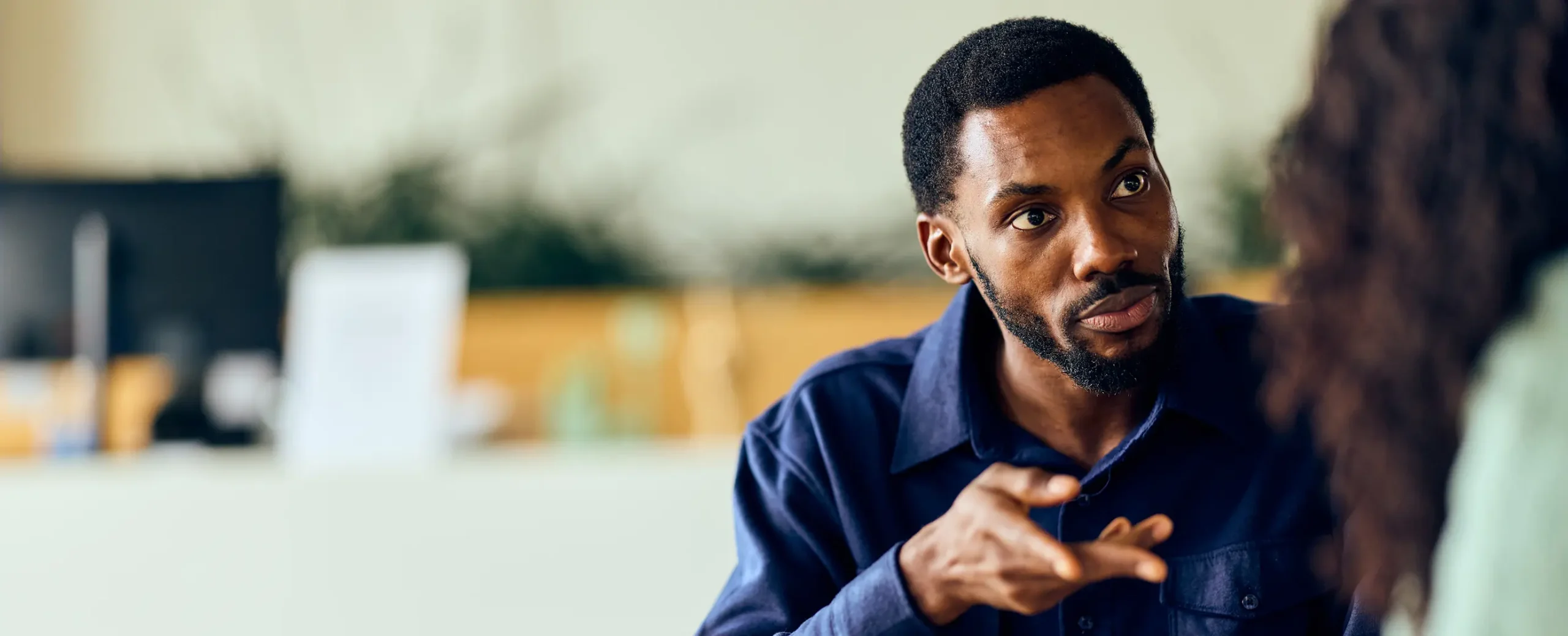 Two coworkers having a conversation in an office.