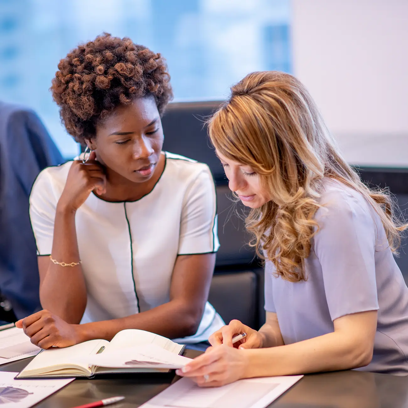 Two coworkers reviewing notes and documents.